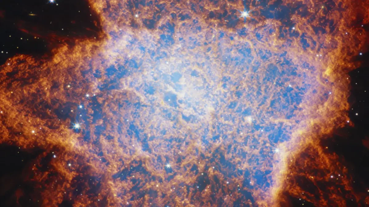 James Webb Space Telescope image of planetary nebula NGC 6072, showing glowing blue gas surrounded by fiery red-orange filaments created by the dying star’s expanding outer layers.