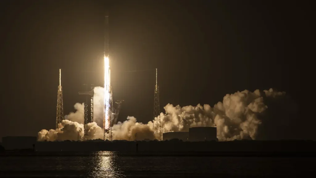 Nighttime rocket launch with smoke and fire illuminating the sky