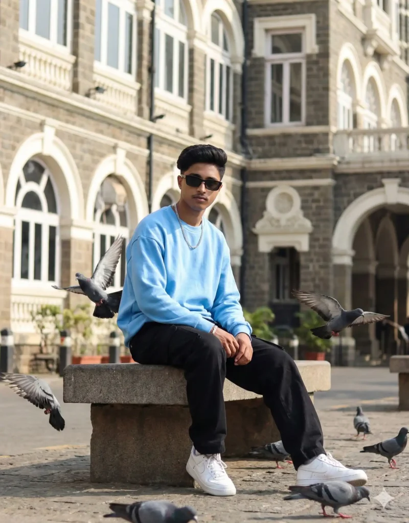 Boy sitting on a stone bench wearing a sky-blue sweatshirt and black pants with pigeons flying around – aesthetic portrait for 5 Gemini AI Photo Editing Prompts for Boys 2025. Scipuz