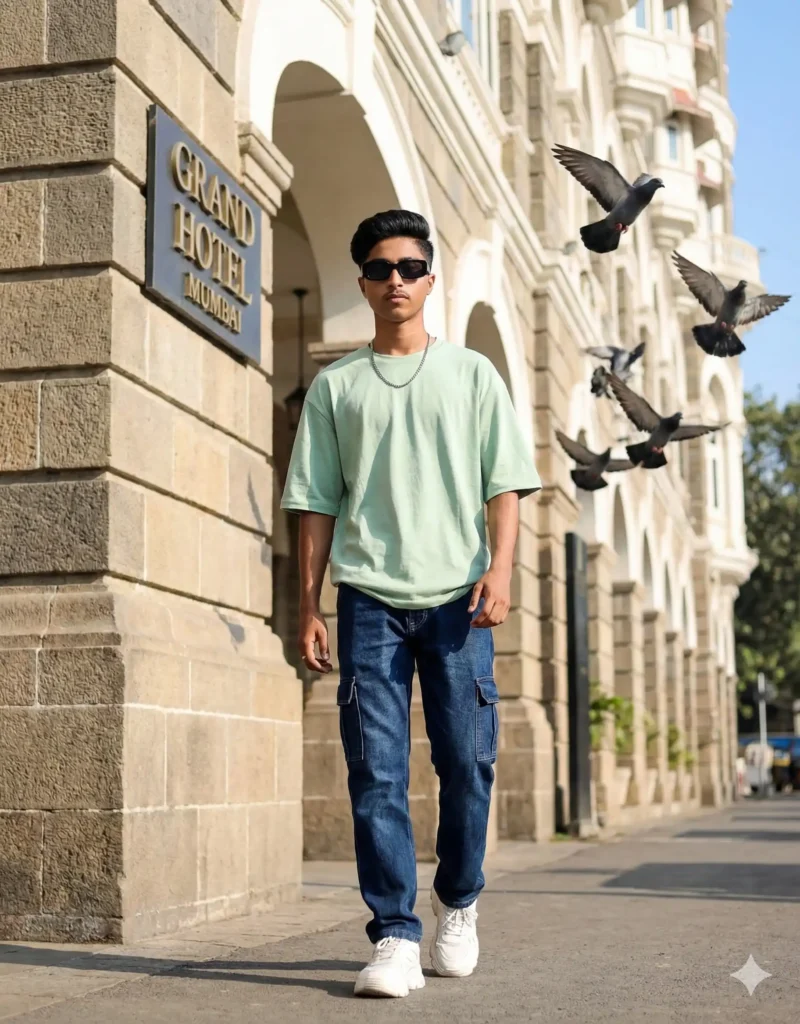Boy walking confidently in mint green oversized T-shirt and dark blue jeans outside Grand Hotel Mumbai – ideal for 5 Gemini AI Photo Editing Prompts for Boys 2025. Scipuz