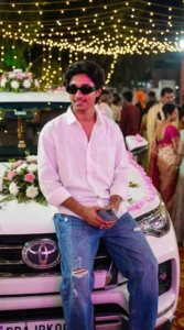 Wedding Photo Prompts for Boys showing a groom sitting confidently with cinematic wedding lights in background