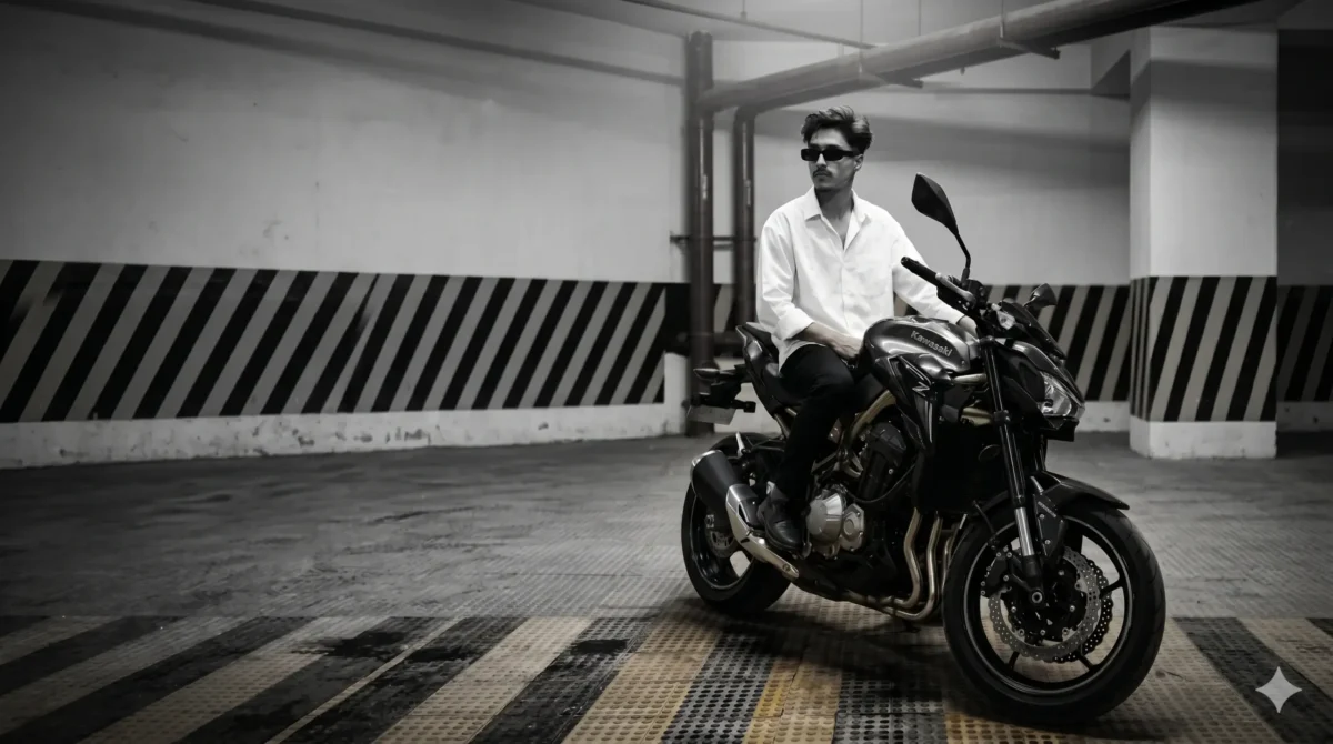 A stylish young man wearing a white shirt and sunglasses sitting on a black Kawasaki Z900 motorcycle in a cinematic underground parking with dramatic lighting. prompt