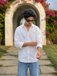 Stylish boy in white shirt and sunglasses posing under floral archway in viral Instagram aesthetic style